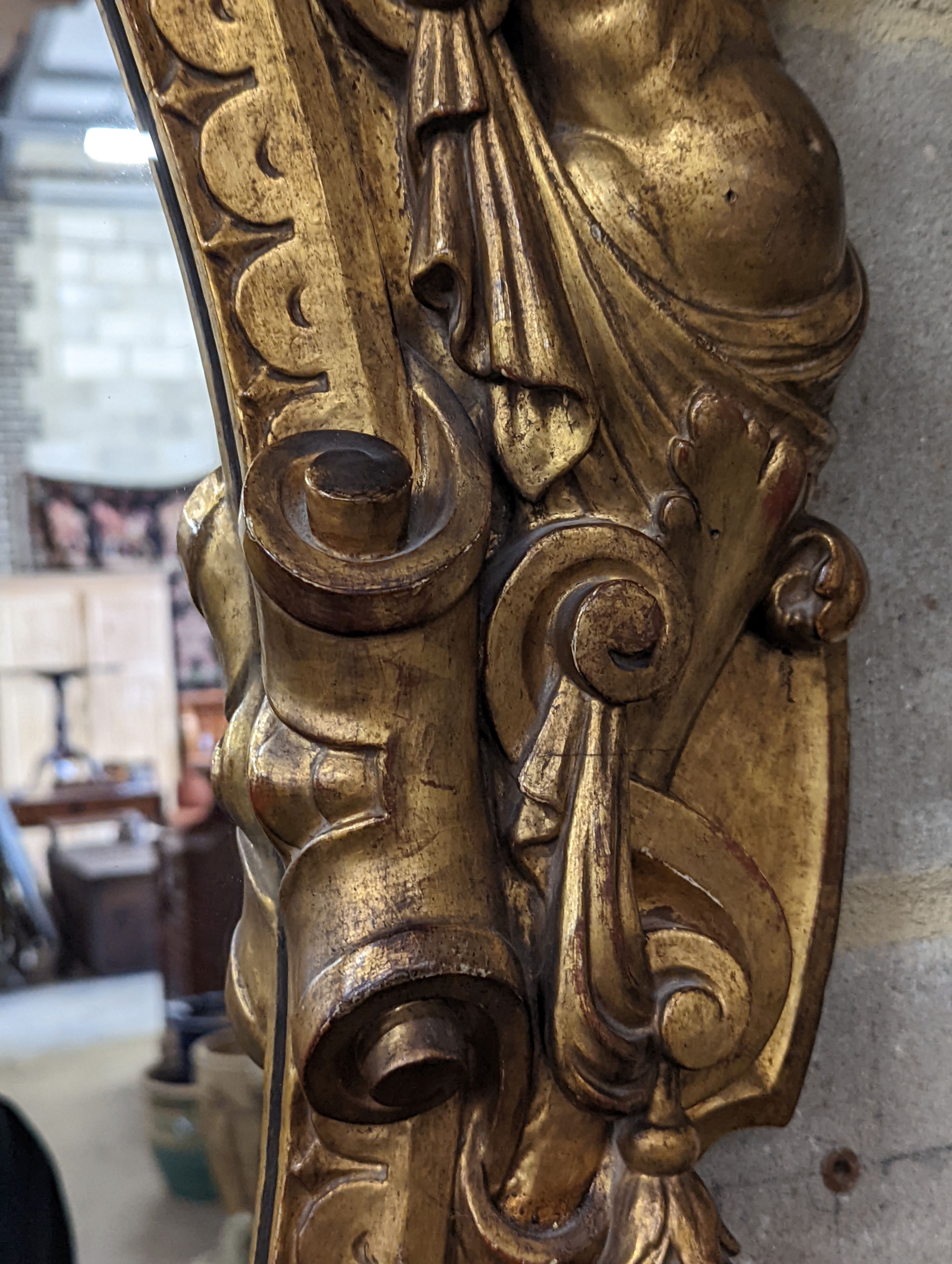 A Victorian carved giltwood oval wall mirror decorated with cherubs and C scrolls., width 74cm, height 110cm
